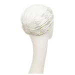 Shakti Turban Printed, Ivory w/Peacock. Its base is white, while the beautiful band features an elegant linen peacock print. It features beautiful peacock details in black and shiny gold and a fine gold trim, making it a very elegant and flattering turban.