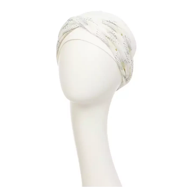 Shakti Turban Printed, Ivory w/Peacock. Its base is white, while the beautiful band features an elegant linen peacock print. It features beautiful peacock details in black and shiny gold and a fine gold trim, making it a very elegant and flattering turban.