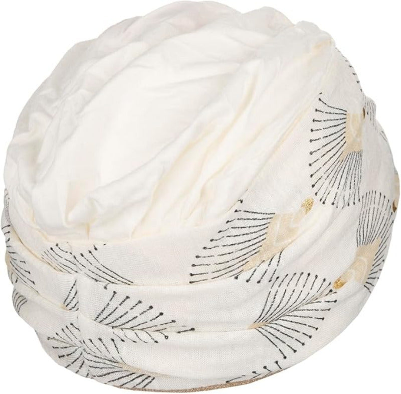 Shakti Turban Printed, Ivory w/Peacock. Its base is white, while the beautiful band features an elegant linen peacock print. It features beautiful peacock details in black and shiny gold and a fine gold trim, making it a very elegant and flattering turban.